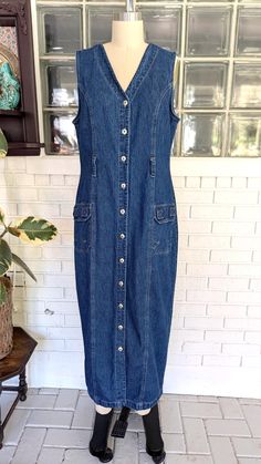 Label: Faded Glory Features: Medium wash denim maxi dress, v neck, sleeveless, full button down front, belt loops at waist, 2 hip hook and loop cargo pockets, fitted at waist.  Tag size: 8/10- Tag sizing is not always accurate so Please refer to measurements for best fit.** Great vintage condition. No holes or stains. MEASUREMENTS taken lying flat and doubled: Length: 50" (from top of shoulder strap down) Chest: 37" Waist: 34" Hips: 40" Please feel free to message me with any questions you might have. **Please understand that all measurements are approximate.** Maxi Dress V Neck, Denim Maxi Dress, Denim Cargo, 90s Denim, Denim Maxi, Button Up Dress, Faded Glory, Dress Clothes For Women, Hook And Loop