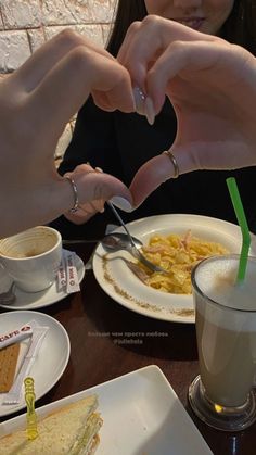 a woman is cutting into a sandwich with a knife and fork at a table full of food