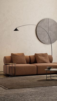 a living room with a couch, coffee table and round mirror on the wall above it