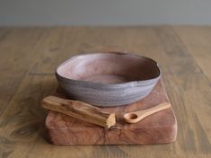 a wooden bowl and spoon sitting on top of a cutting board