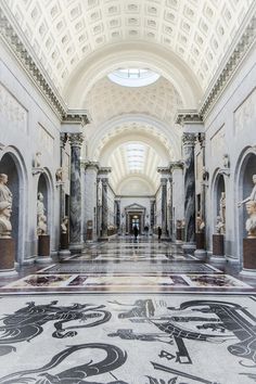 the inside of a building with statues on the walls and ceiling, along with marble flooring