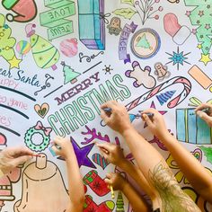 three people are drawing on a wall with colored pencils and crayon markers