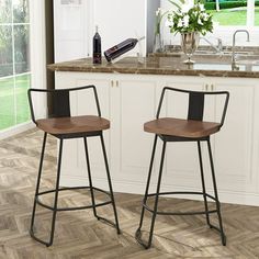 two bar stools sitting in front of a kitchen counter