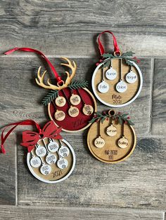 three christmas ornaments hanging on a wooden wall with red ribbon and tags attached to them