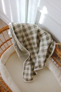 a baby's bed with a blanket on top of it