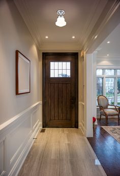 an empty hallway with wooden doors and hard wood flooring on either side of the door