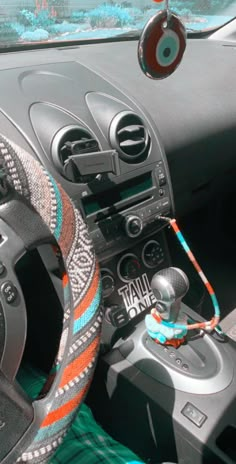 the interior of a car with an orange and blue steering wheel cover