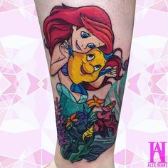 the little mermaid tattoo is on someone's leg