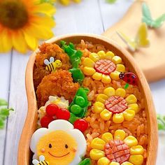 a wooden bowl filled with lots of food and decorations on top of a white table