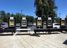 a row of parking meters sitting next to each other on top of a cement ground