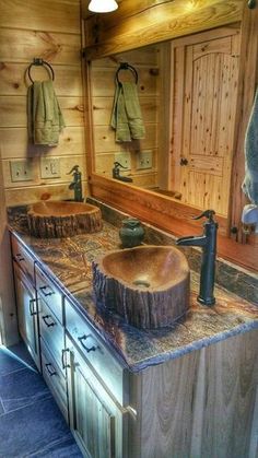 a rustic bathroom with two sinks and wood accents on the countertop, along with wooden cabinets