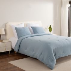 a bed with blue comforter and pillows in a bedroom