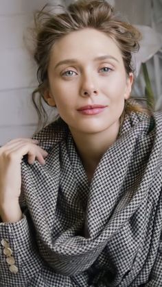 a woman is wearing a scarf and posing for the camera