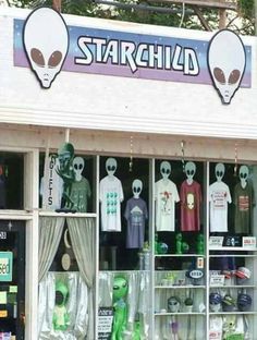 a store front with alien heads and t - shirts on display in it's windows