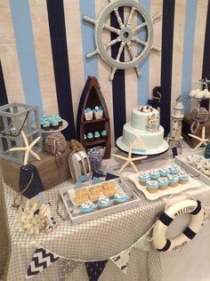 a table topped with cakes and cupcakes next to a wall