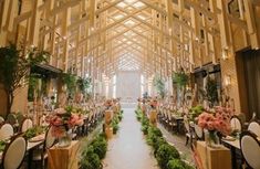 the inside of a building with tables and chairs set up for a formal dinner or function