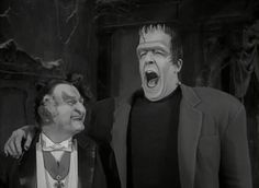 two men dressed as dracula and the man in the black suit has his mouth open