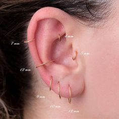 a woman's ear is shown with three different types of piercings