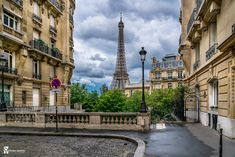 the eiffel tower towering over the city of paris, from an alleyway