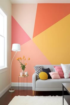 a living room with an orange, yellow and pink color scheme painted on the wall