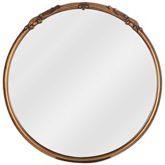 a round mirror with an ornate frame