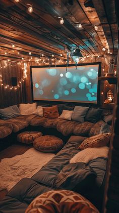 a large couch sitting in front of a projector screen with lights on the ceiling