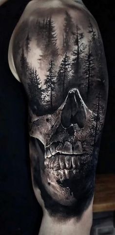 a man's arm with a skull and trees on it