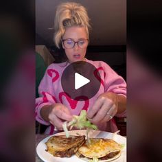 a woman in pink shirt preparing food on white plate