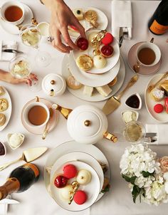 an overhead view of people eating at a table with tea and desserts on it