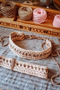 crocheted bracelets and headbands on a table with yarn in the background