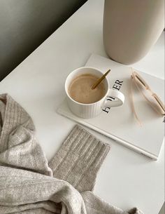 a cup of coffee sitting on top of a table next to a pair of socks