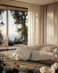 a bed with white sheets and pillows in front of a window overlooking the ocean on a sunny day