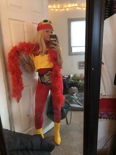 a woman dressed in red and yellow taking a selfie with her cell phone while standing in front of a mirror