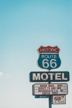 an old route 66 motel sign in front of a blue sky