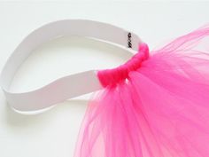 a pair of scissors with pink tulle attached to it