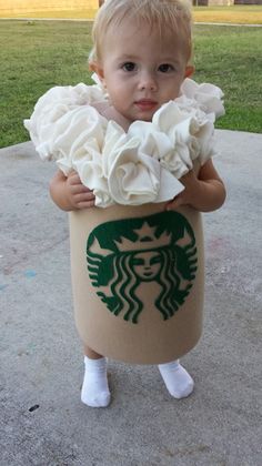 a baby in a starbucks cup costume holding flowers