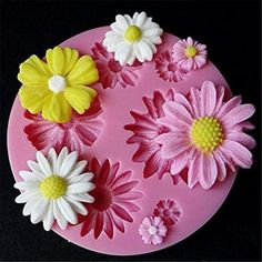 a pink cake with white and yellow flowers on it