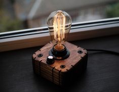 a light bulb sitting on top of a wooden block next to a window sill