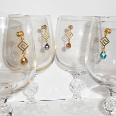 three wine glasses with different designs and colored beads on the bottom one has a black handle