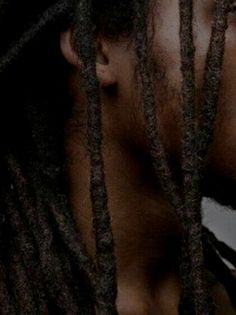 a man with dreadlocks is staring at something