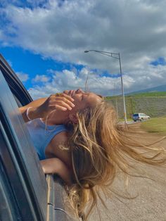 a woman leaning out the window of a car