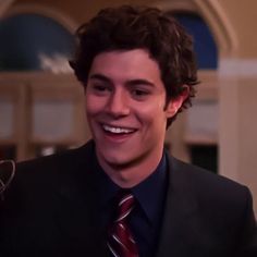 a smiling young man in a suit and tie