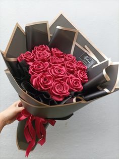 a person holding a large bouquet of red roses