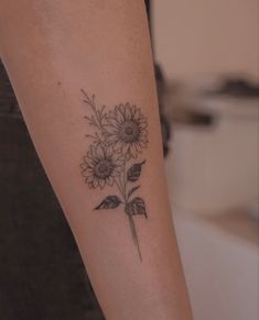 a woman's arm with a flower tattoo on it