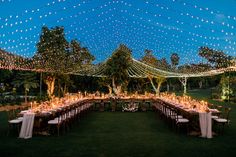 an outdoor wedding reception setup with string lights