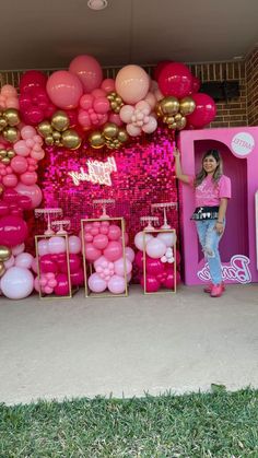 a barbie birthday party with pink and gold balloons on the wall, balloon arch and decorations