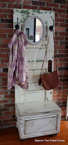 an old door with a mirror, coat rack and purse hanging on the wall next to it