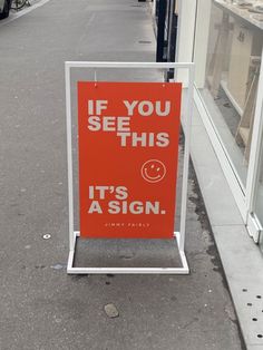 an orange sign that says if you see this it's a sign on the sidewalk