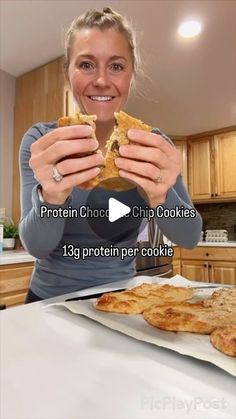 a woman holding up a piece of bread in front of her face with the words protein choc chip cookies on it