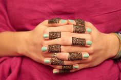 a woman's hands with henna tattoos on them